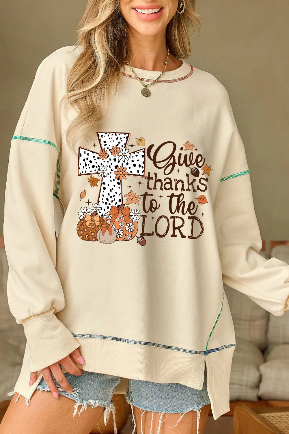 Beige graphic cross sweatshirt with pumpkins, leaves, and "Give thanks to the Lord" text.