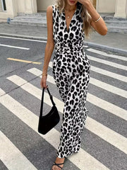 Sleeveless leopard print romper with V-neck and cinched waist, styled with a black shoulder bag.