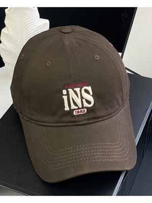 Brown baseball cap with embroidered New York INS 1982 detail