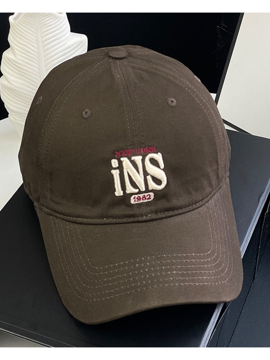 Brown baseball cap with embroidered New York INS 1982 detail