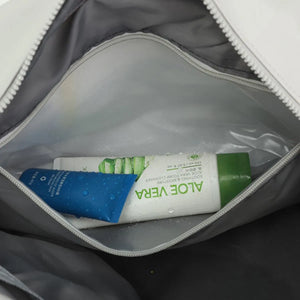 Interior view of a white duffle bag showing Aloe Vera cleanser and blue cream.