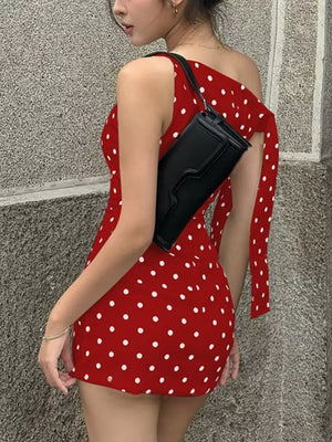 Red polka dot mini dress with asymmetrical bow detail and one shoulder strap.