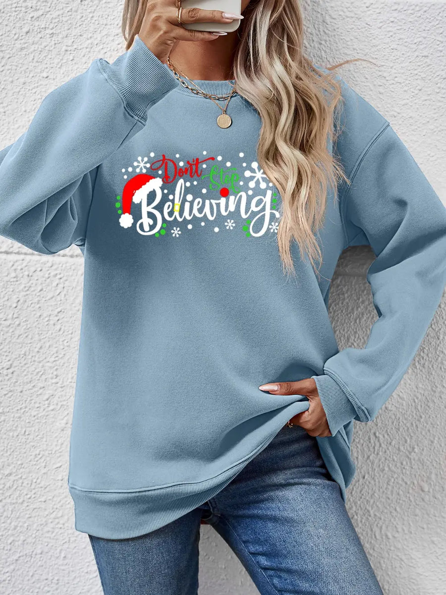 Air Force Blue long sleeve sweater with "Don't Stop Believing" graphic and Santa hat detail.