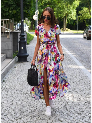 Maxi wrap dress with a vibrant floral print, V-neck, short sleeves, and a high slit.