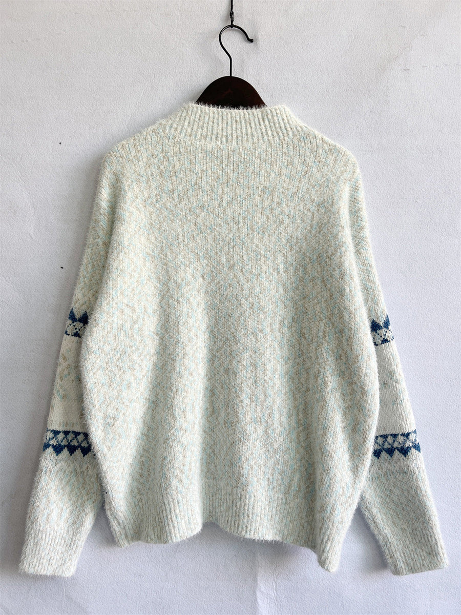 Geometric knit mockneck pullover in Eggshell with blue diamond pattern on sleeves.
