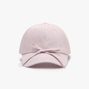 Blush pink baseball cap with a tied back bow detail