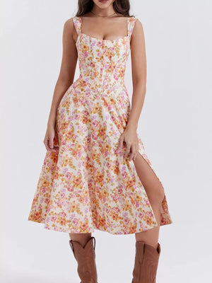 Floral midi dress with side slit and sweetheart neckline in cream with pink and orange flowers.