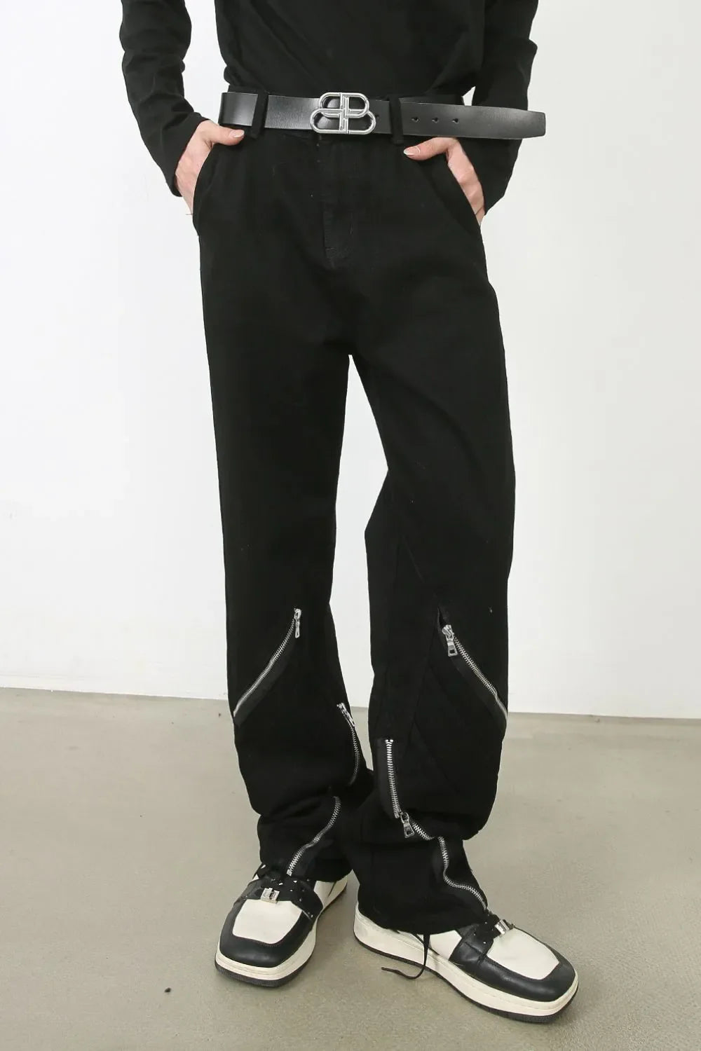 Zipped hem black denim trousers with silver zipper details.
