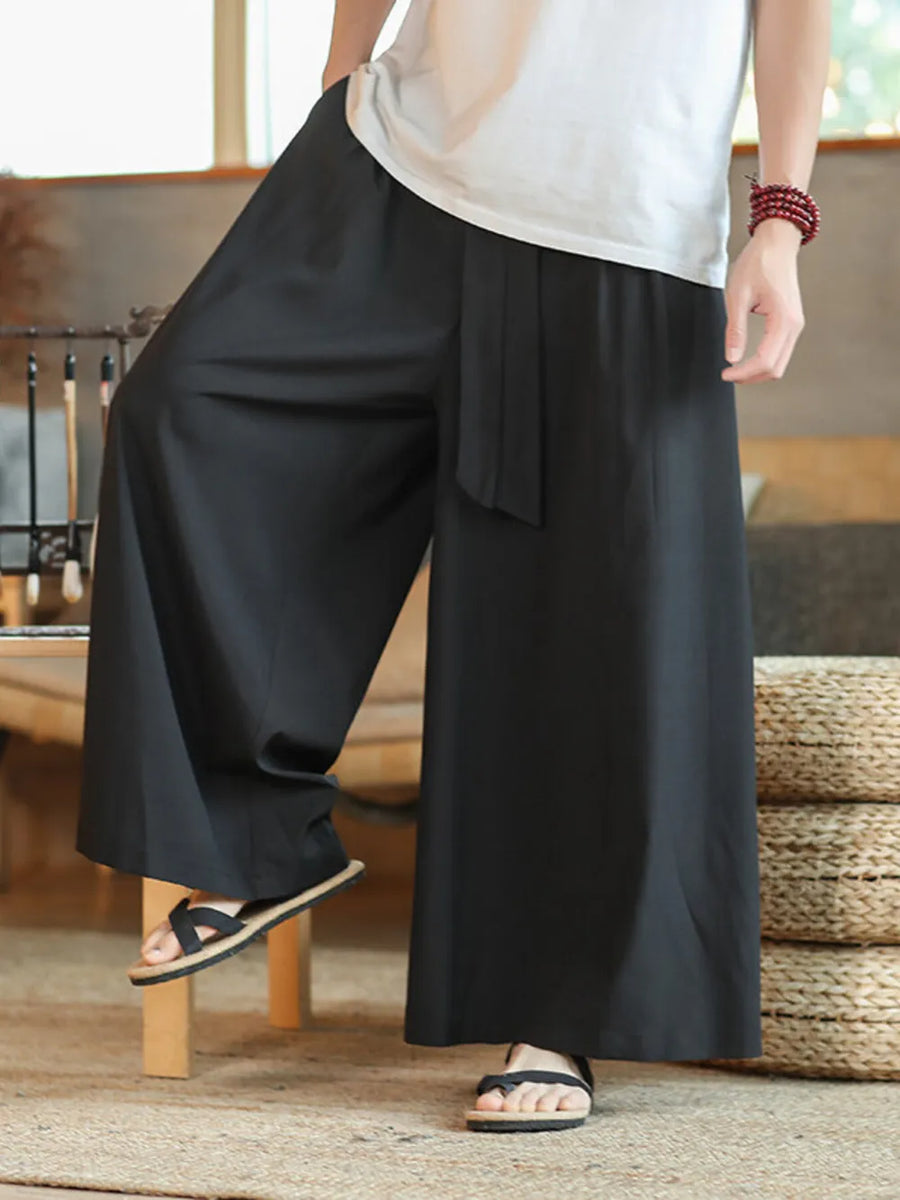 Men's black wide-leg sweatpants with drawstring and tie detail.