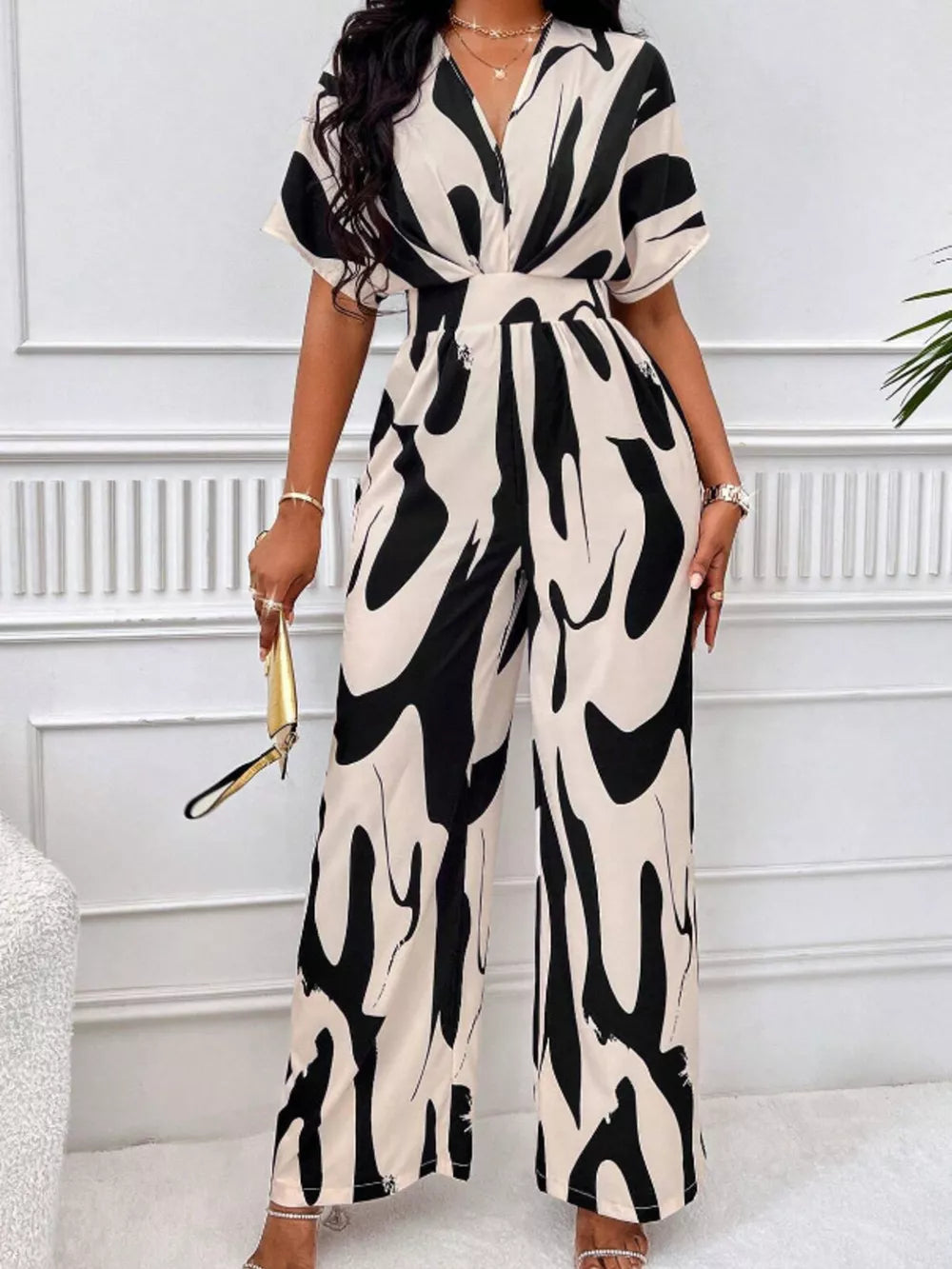 Black and white abstract print wide-leg romper with V-neck and short sleeves.