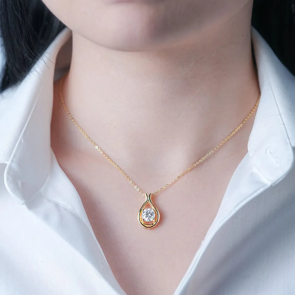 Gold teardrop pendant necklace with moissanite on a delicate chain.