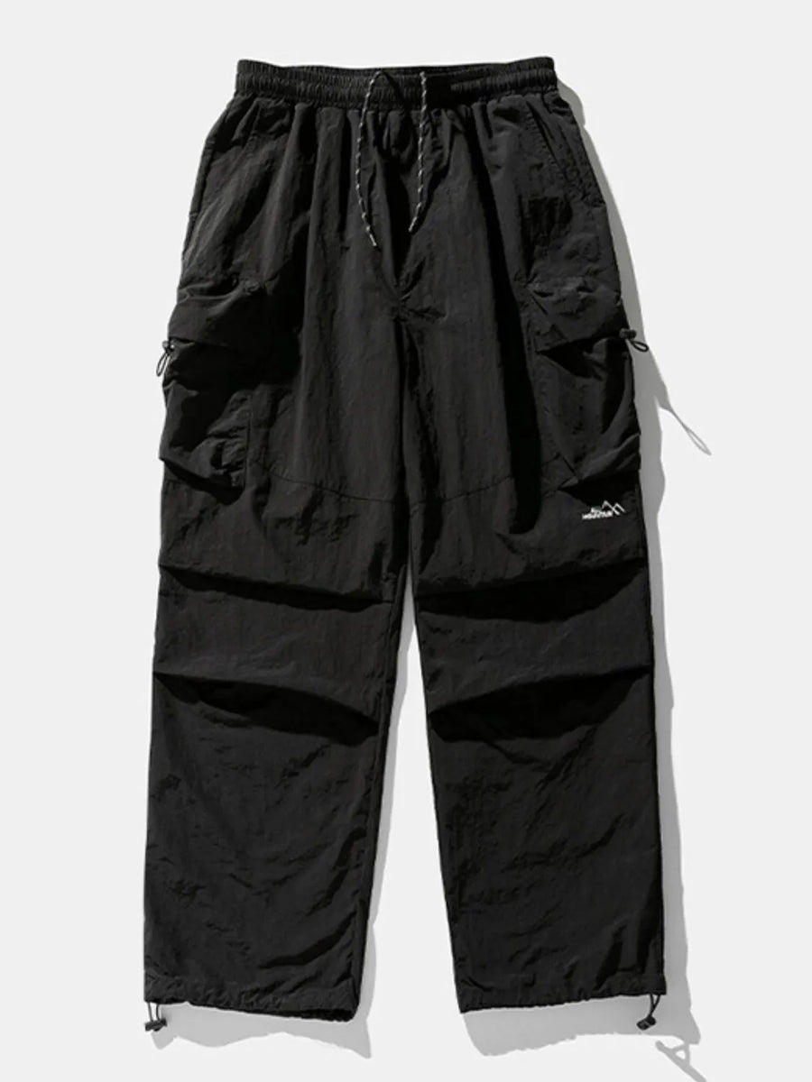 Black oversized utility cargo pants with drawstring waist and multiple cargo pockets.
