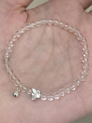 Clear crystal bead bracelet with silver butterfly and ball charms.