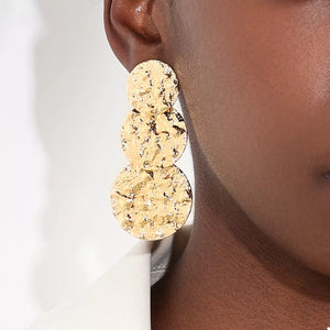 earrings in gold with textured and layered