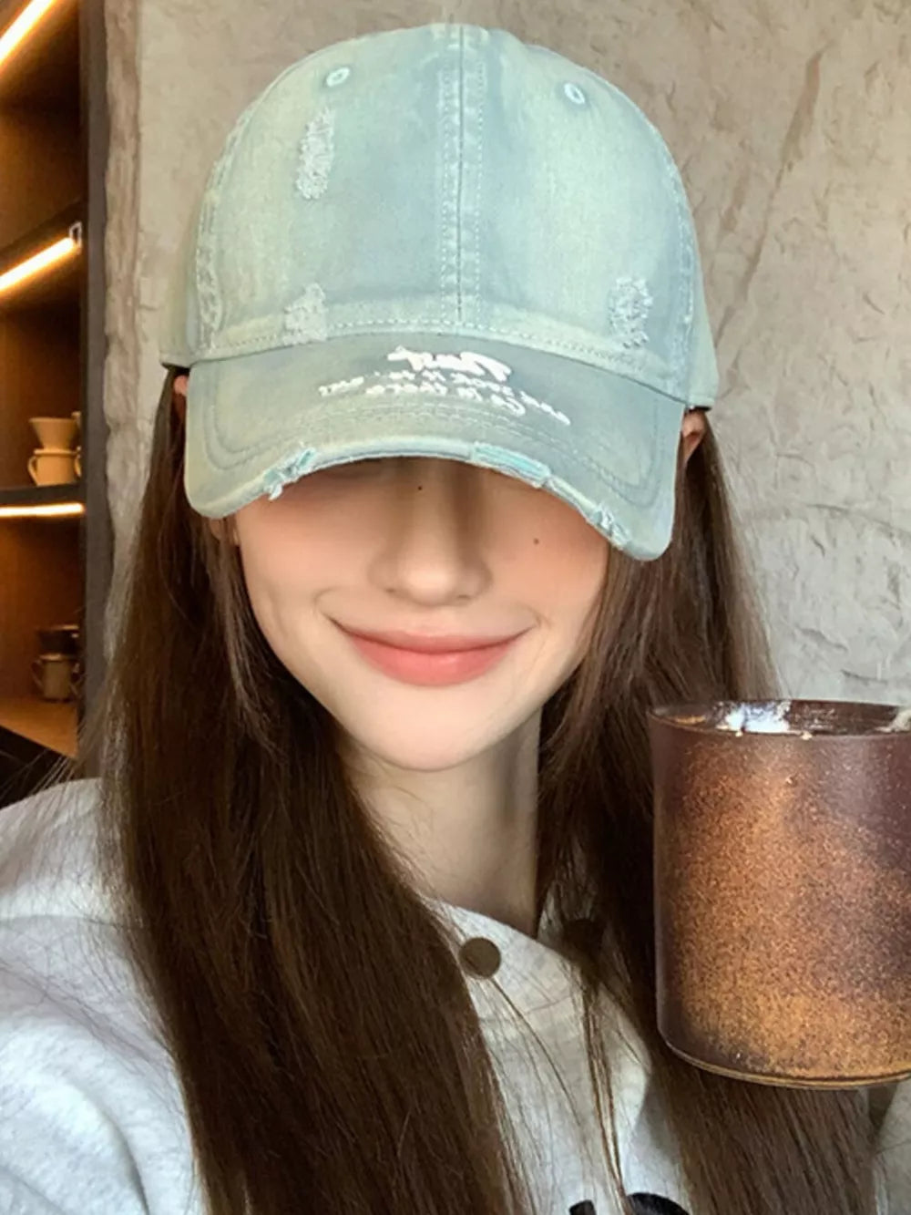 Distressed baseball cap in dirty blue cotton with embroidered detail and frayed brim.
