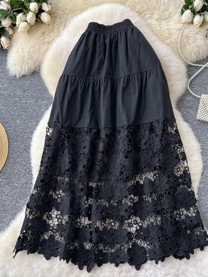 Black tiered midi skirt with elastic waist and intricate floral lace overlay.