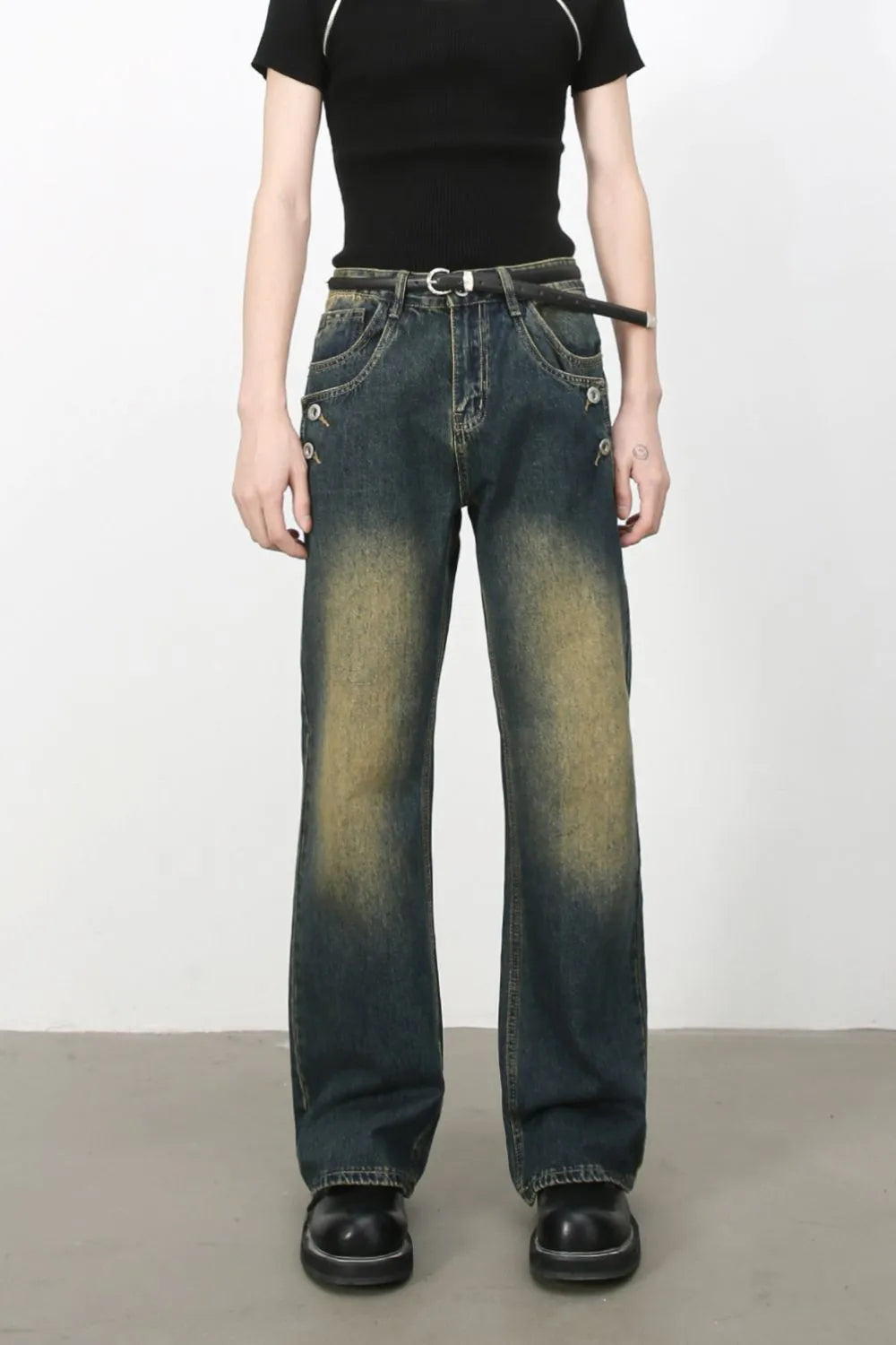 Dark wash bootcut jeans with button details and faded accents.