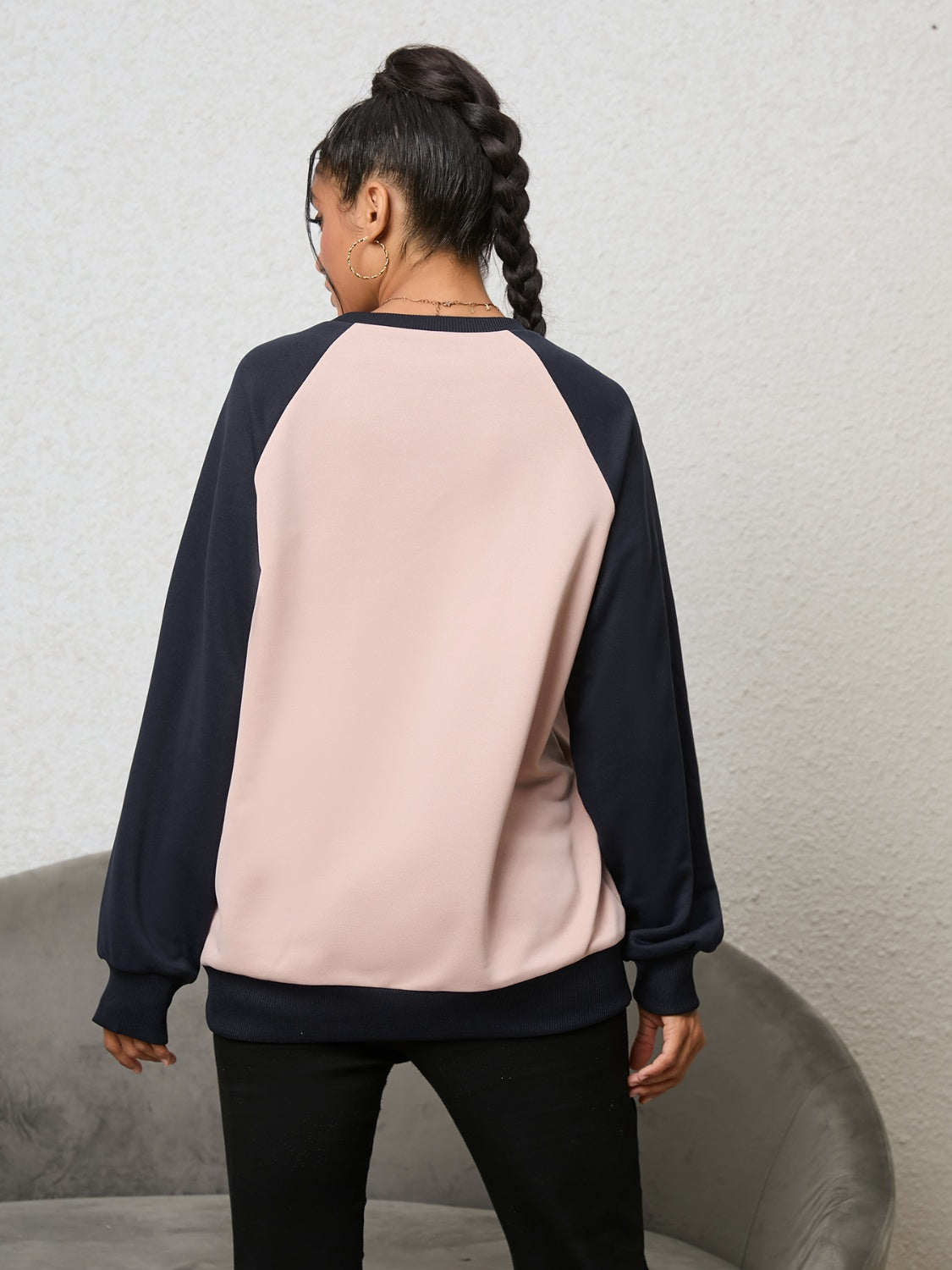 Blush pink and navy raglan sweatshirt with crew neck and cuffed sleeves.