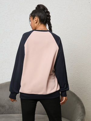 Blush pink and navy raglan sweatshirt with crew neck and cuffed sleeves.