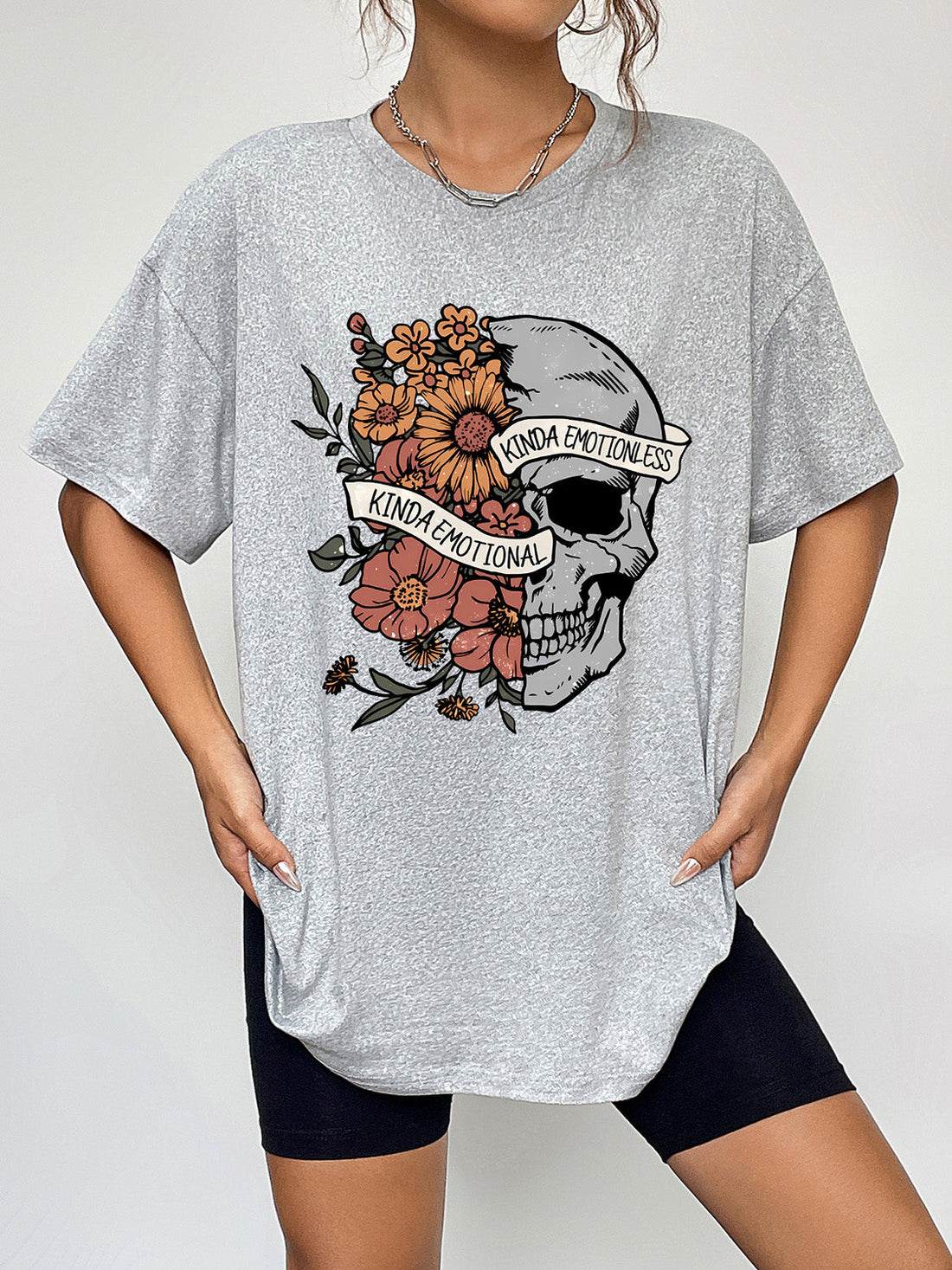 Grey oversized t-shirt with a skull and floral graphic that says Kinda Emotional.