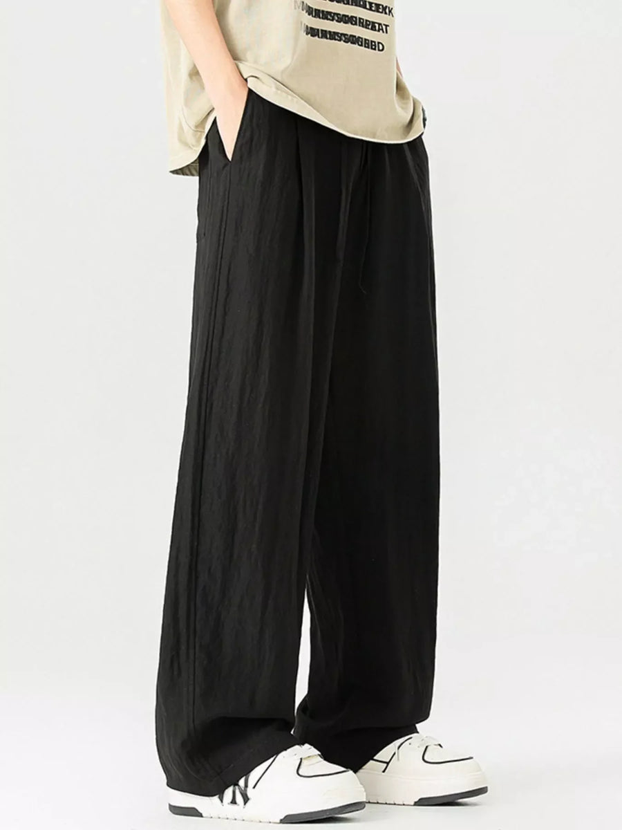Black lightweight wide-leg trousers with drawstring waist and pockets.