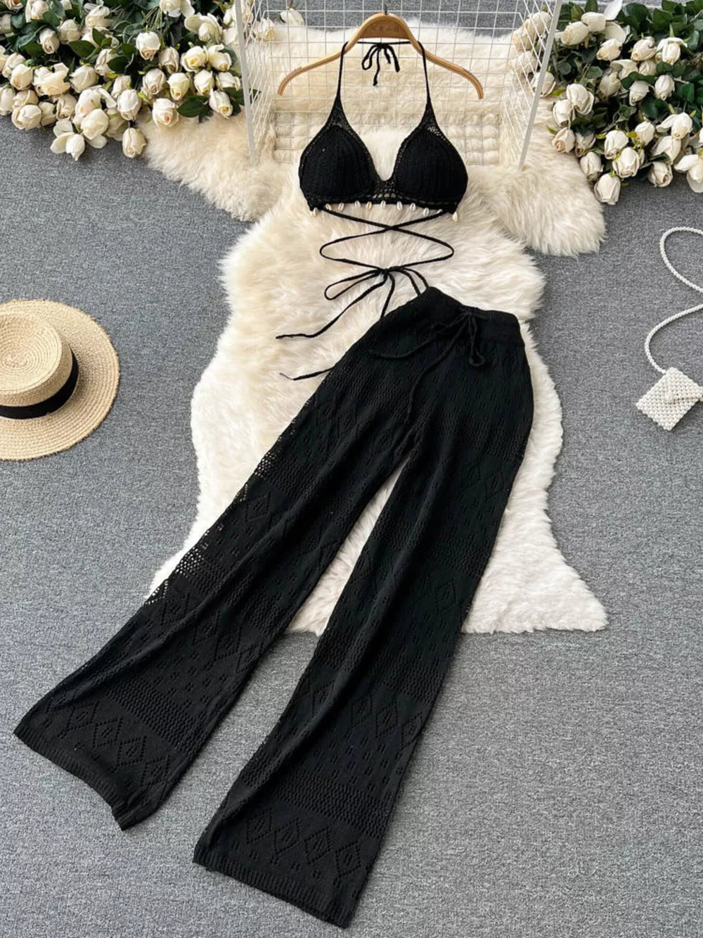 Black crochet halter bikini top and wide-leg pants set with shell detail.