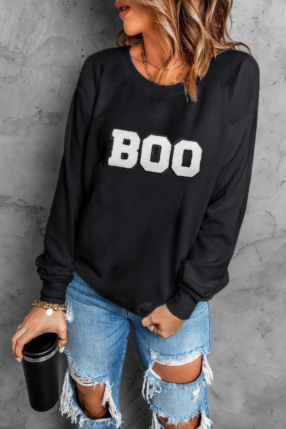 Black crewneck sweatshirt with white varsity "BOO" graphic detail