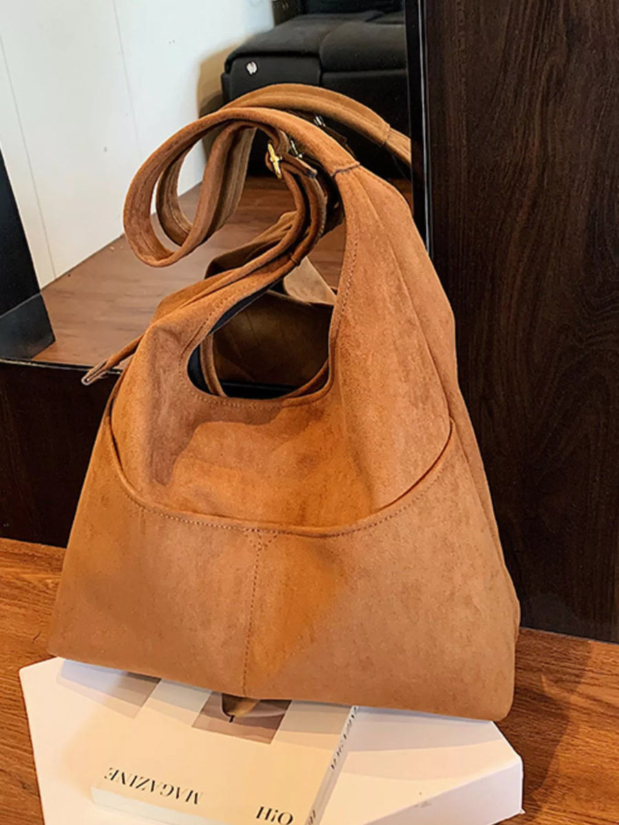 Large brown suede shoulder bag with a slouchy design and adjustable strap.