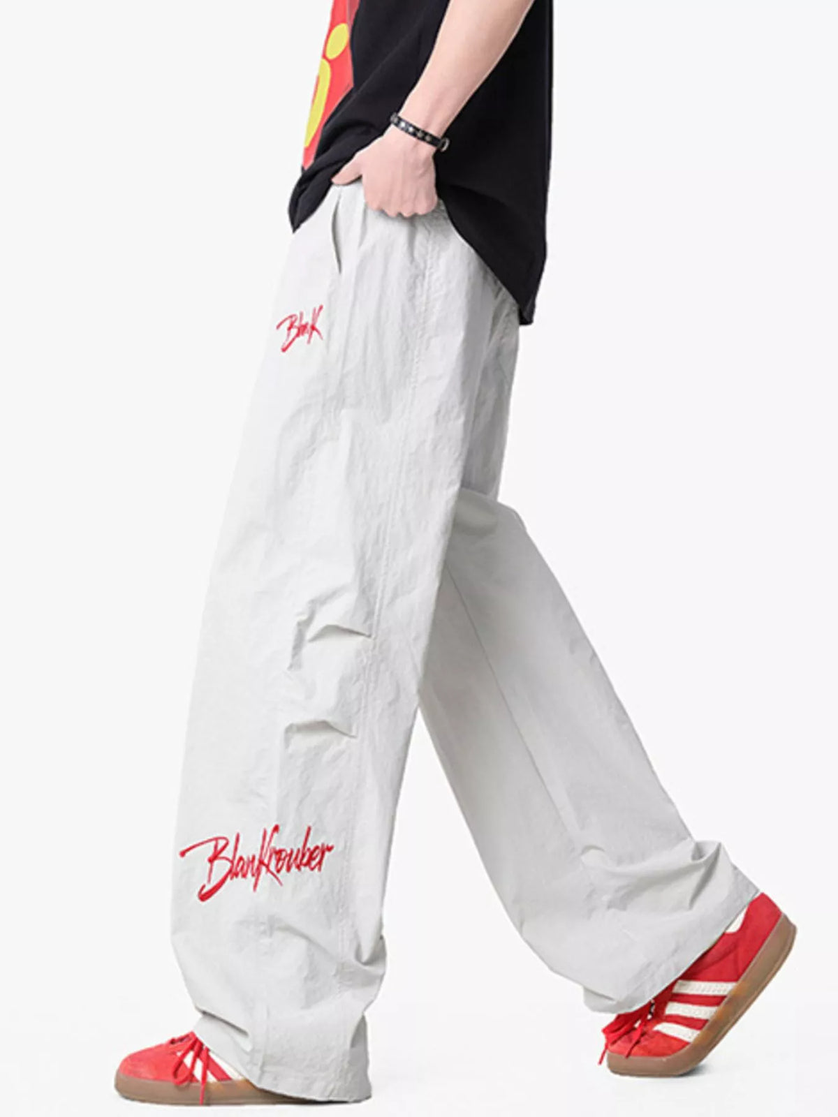Lightweight wide-leg pants in light gray with red embroidered logo detail and drawstring waist.