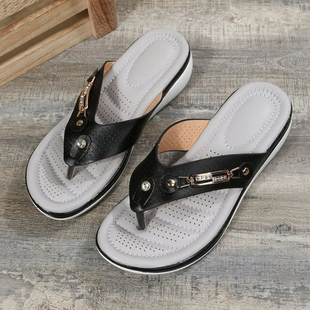 Black perforated thong wedge sandals with jeweled embellishments and a cushioned footbed.