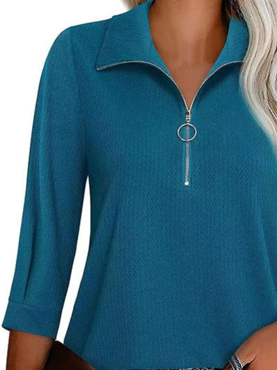Peacock blue textured zip-front polo top with a ring pull zipper and collar.