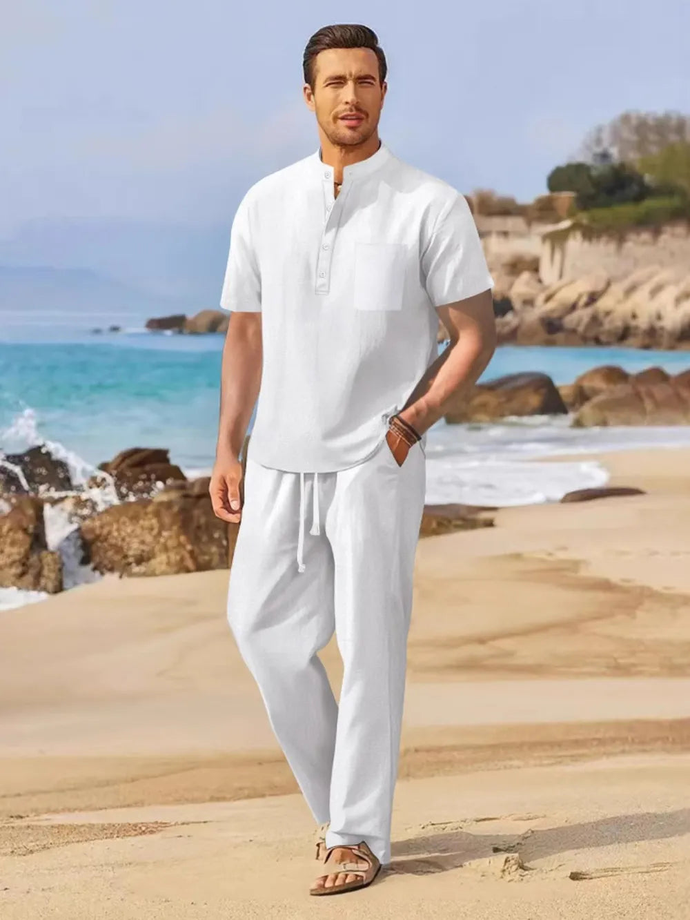 White linen henley shirt and drawstring trousers set on a beach