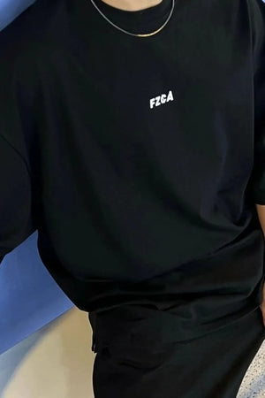 Black oversized tee with drop shoulder and small white chest logo