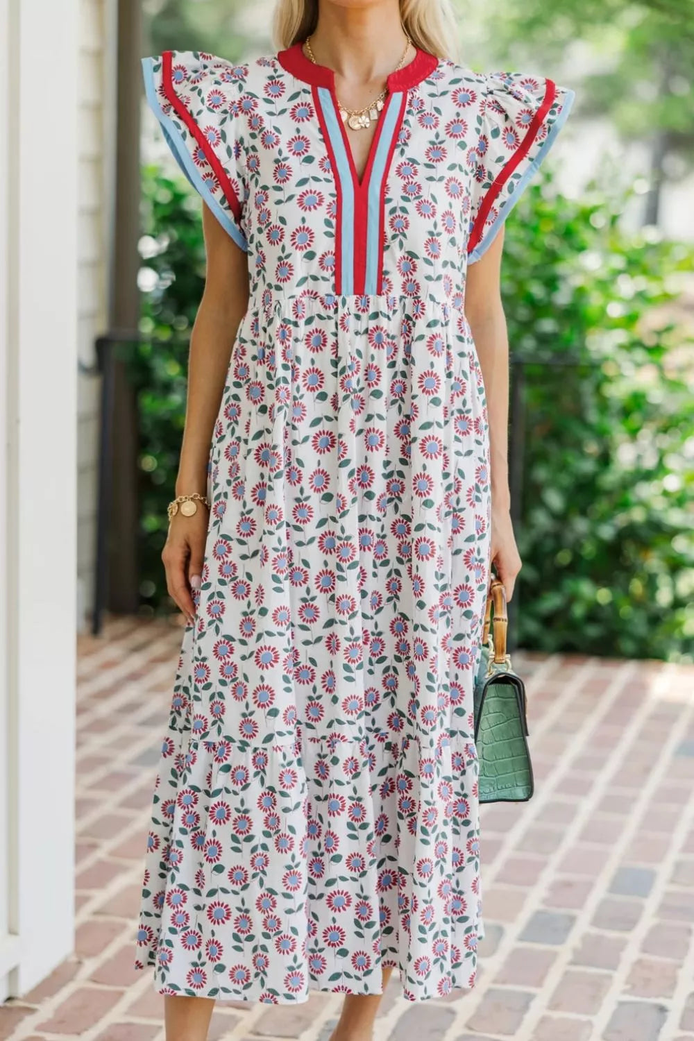 Vibrant floral tiered midi dress with red and blue trim, flutter sleeves, and a V-neck.