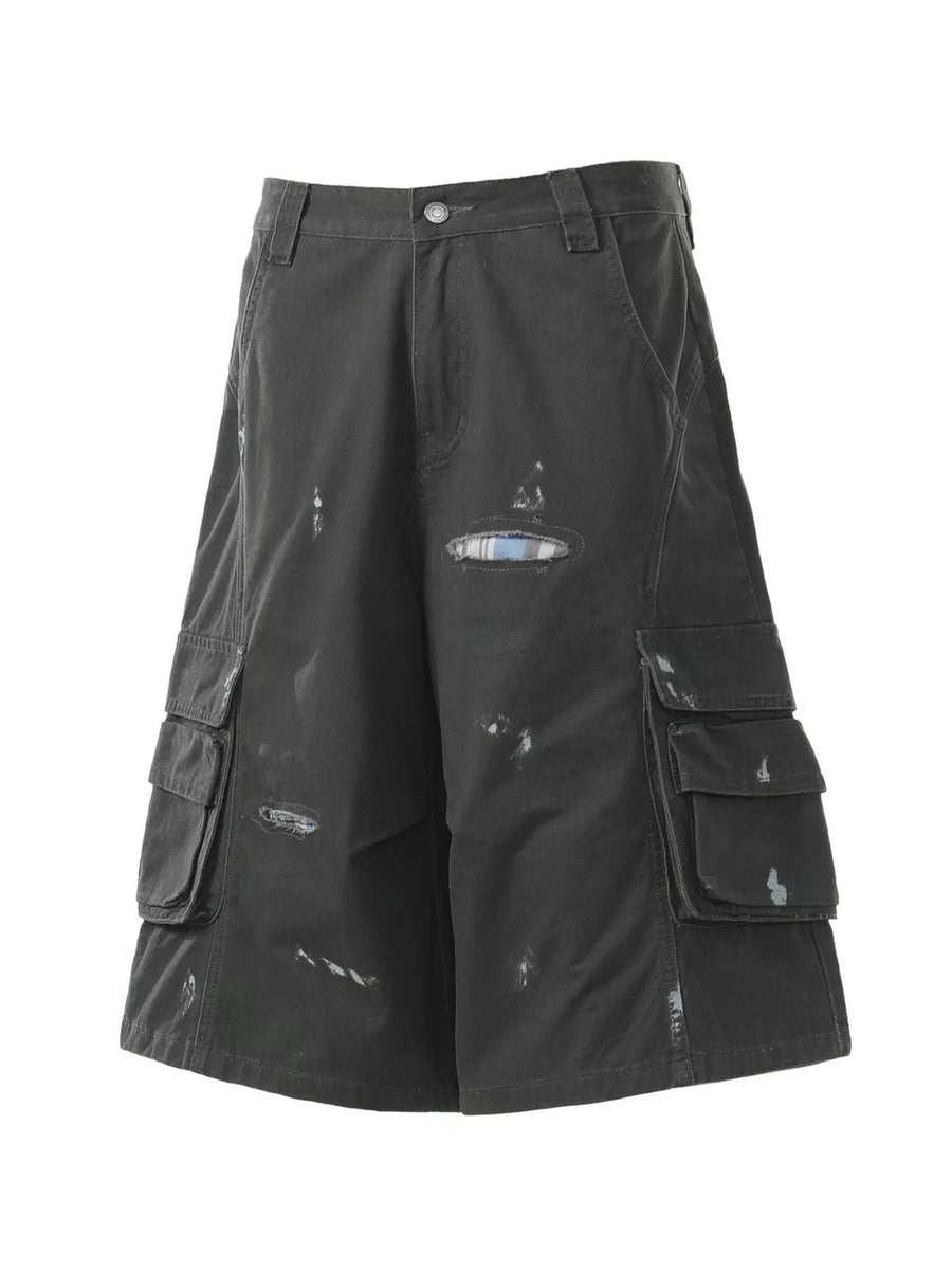 Black distressed maternity cargo capris with multiple pocket details and a plaid patch.