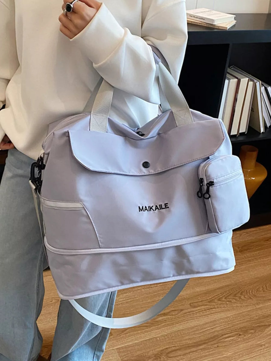 Lilac duffel bag with MAIKAILE logo and multiple zippered pockets.