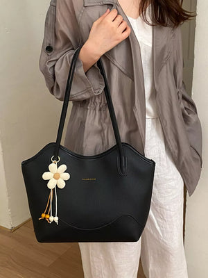 handbag in black featuring shoulder straps and structured fit