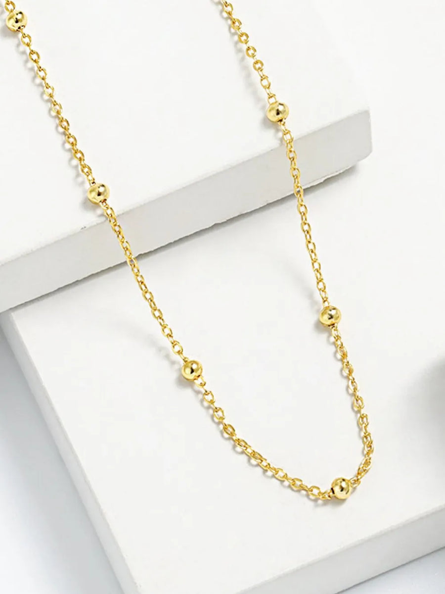 Gold delicate orb chain necklace with small spherical beads spaced along the chain.