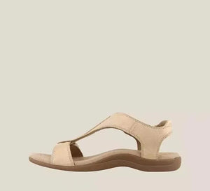 Beige leather T-strap comfort sandals with a contoured footbed and adjustable ankle strap.