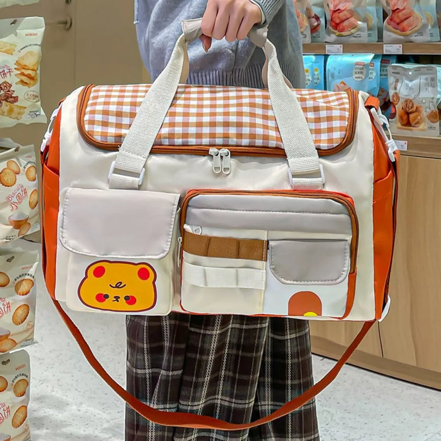 Charming gingham pattern travel bag with double zippers and cute bear applique.