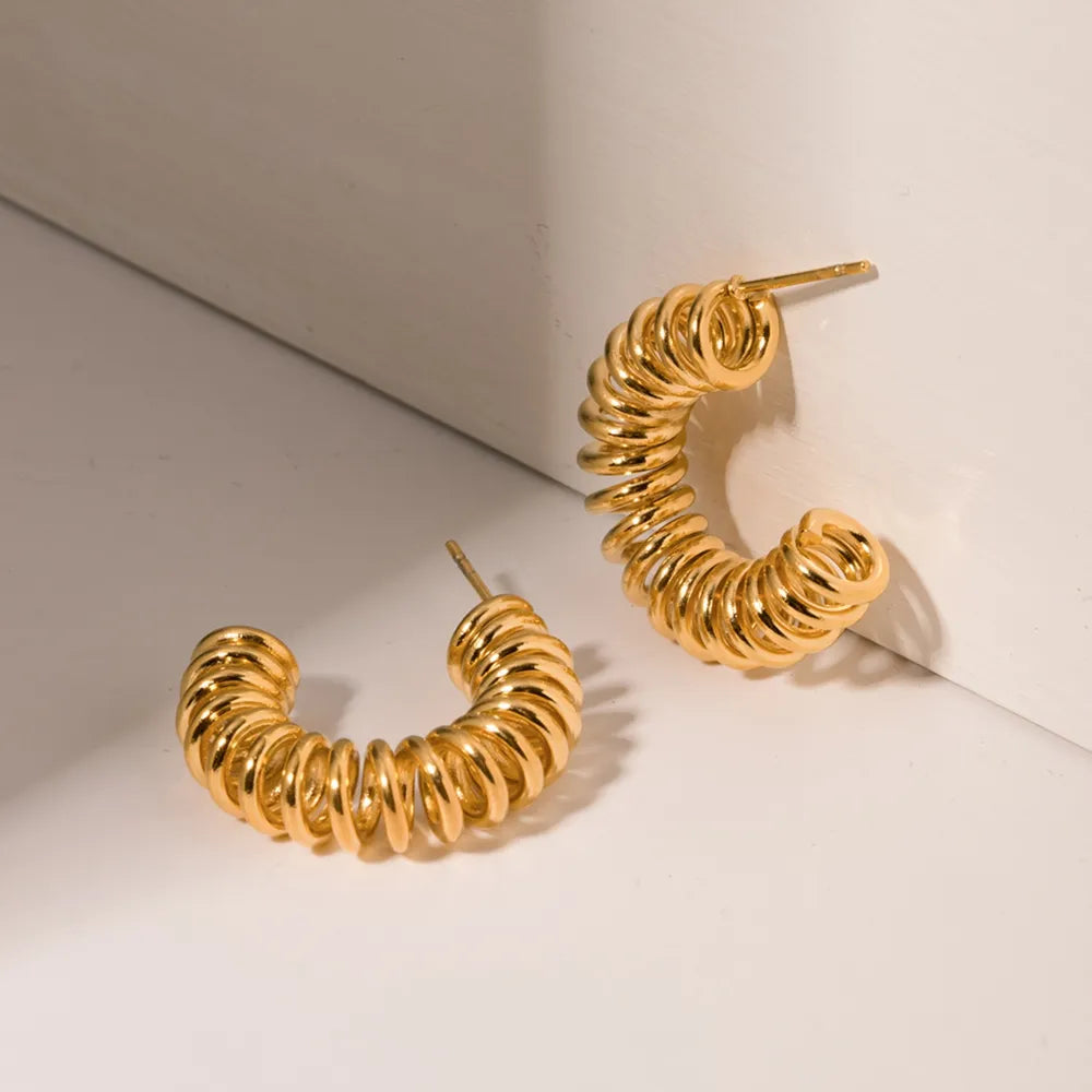 Gold vermeil spiral coil hoop earrings with a textured finish.