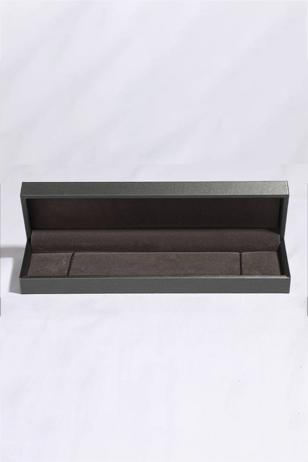 Open dark grey jewelry box with velvet lining for a bracelet