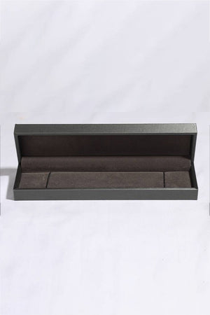 Open dark grey jewelry box with velvet lining for a bracelet