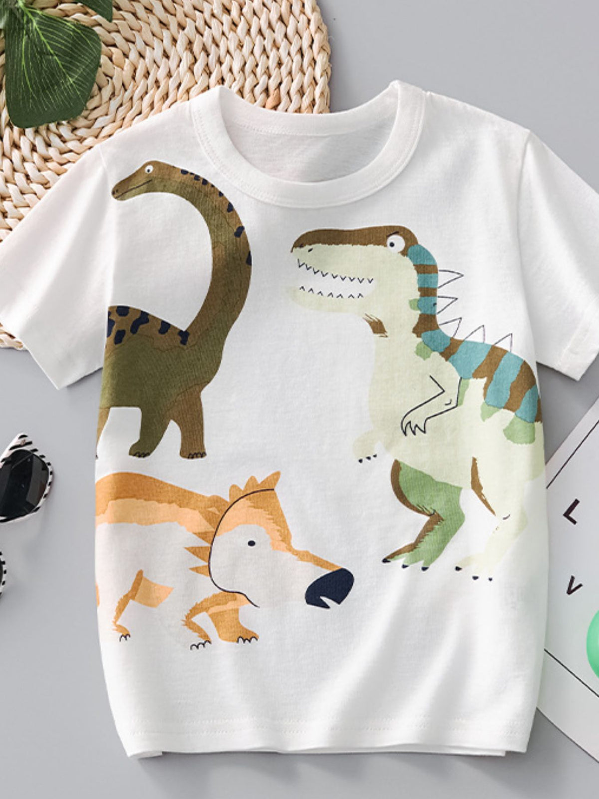 White cotton crew-neck t-shirt with a playful dinosaur print for toddlers.
