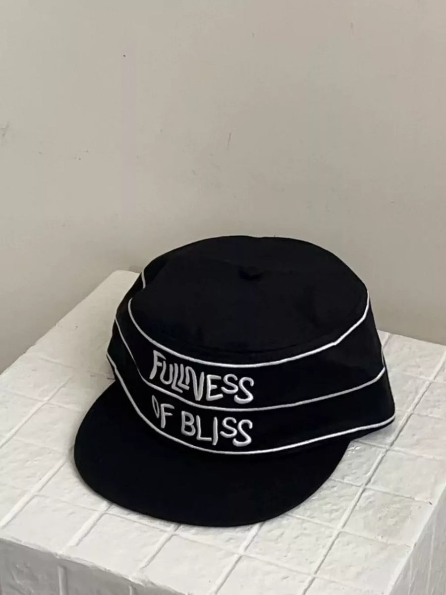 Black cotton baseball cap with embroidered slogan and white piping detail