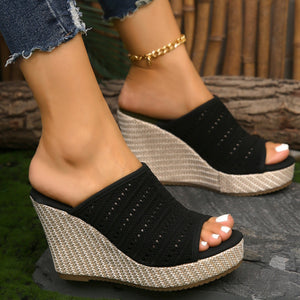 Black perforated espadrille wedge sandals with woven platform and heel.