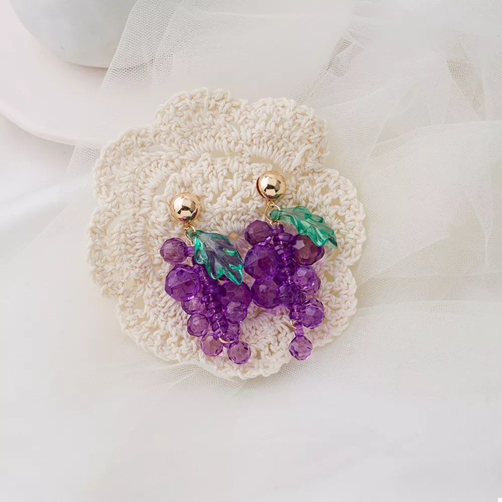 Grape-inspired beaded dangle earrings with green acrylic leaves and gold posts.