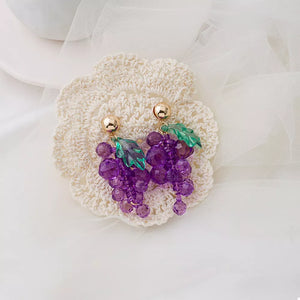 Grape-inspired beaded dangle earrings with green acrylic leaves and gold posts.