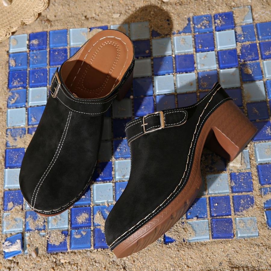 Black round toe platform slip-ons with buckle detail and contrast stitching.