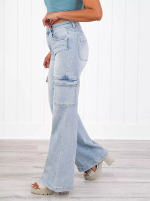 Light wash denim wide-leg cargo pants with flap pockets and a relaxed fit.
